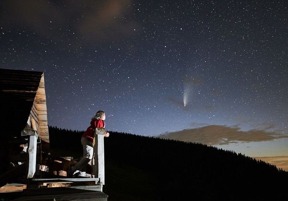 Woman enjoying beautiful starry night 