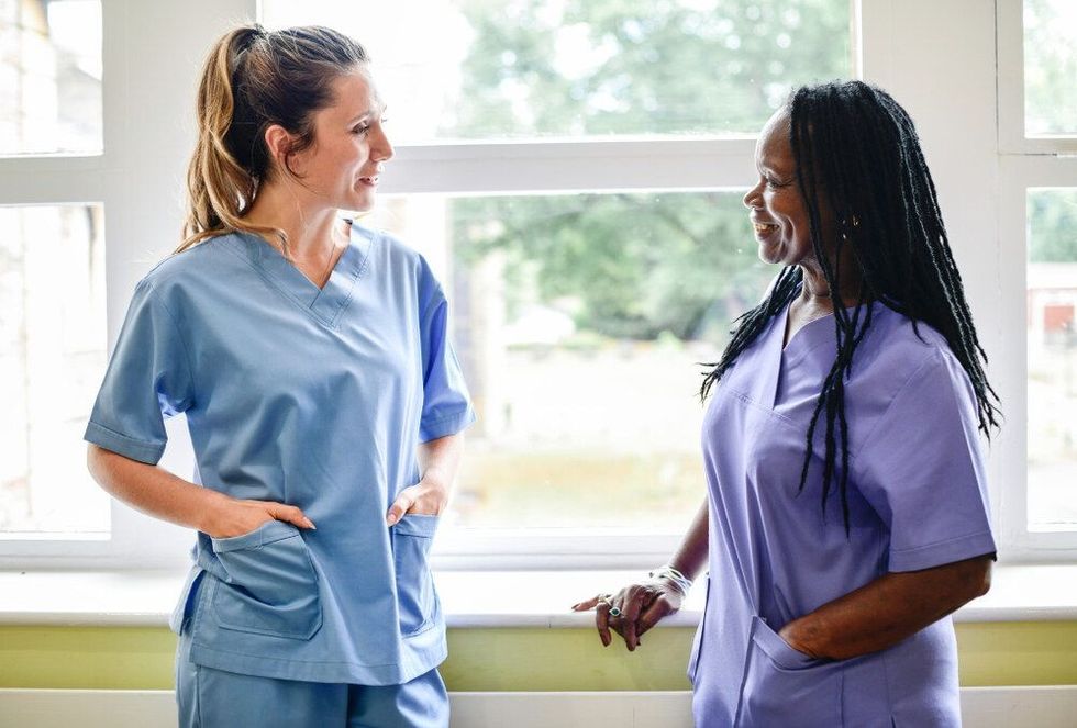 Woman in hospital scrubs talking to each other while smiling
