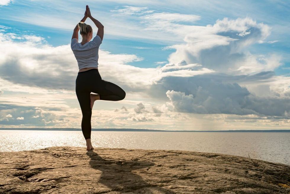 Woman practicing self discipline by meditating near a cliff edge