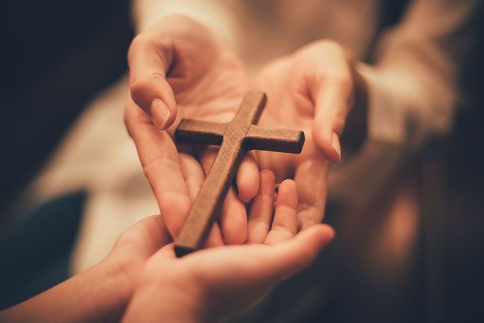 Women showing faith with cross sign in her hand