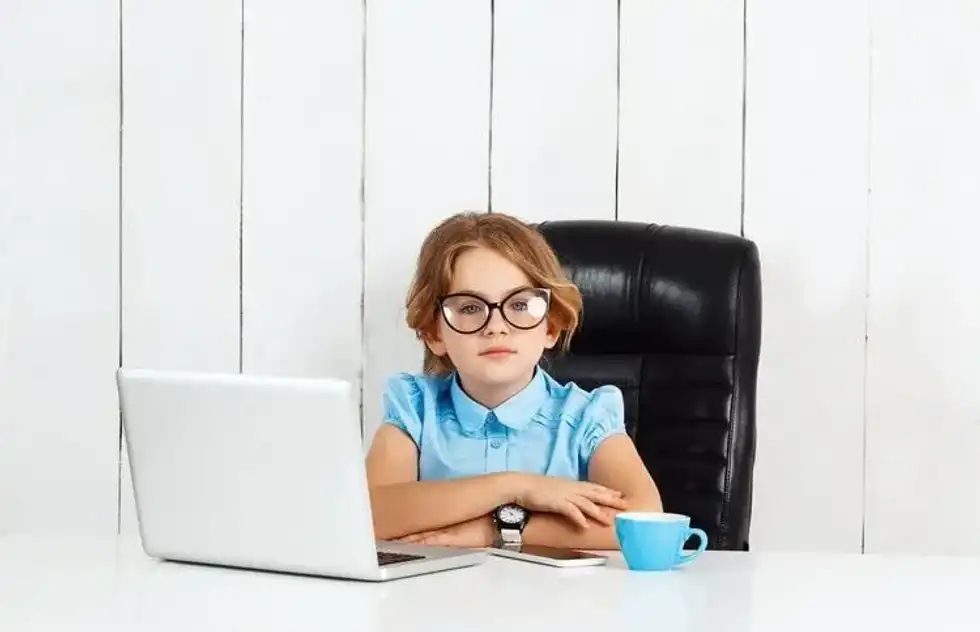 Young beautiful girl sitting at working place in office.