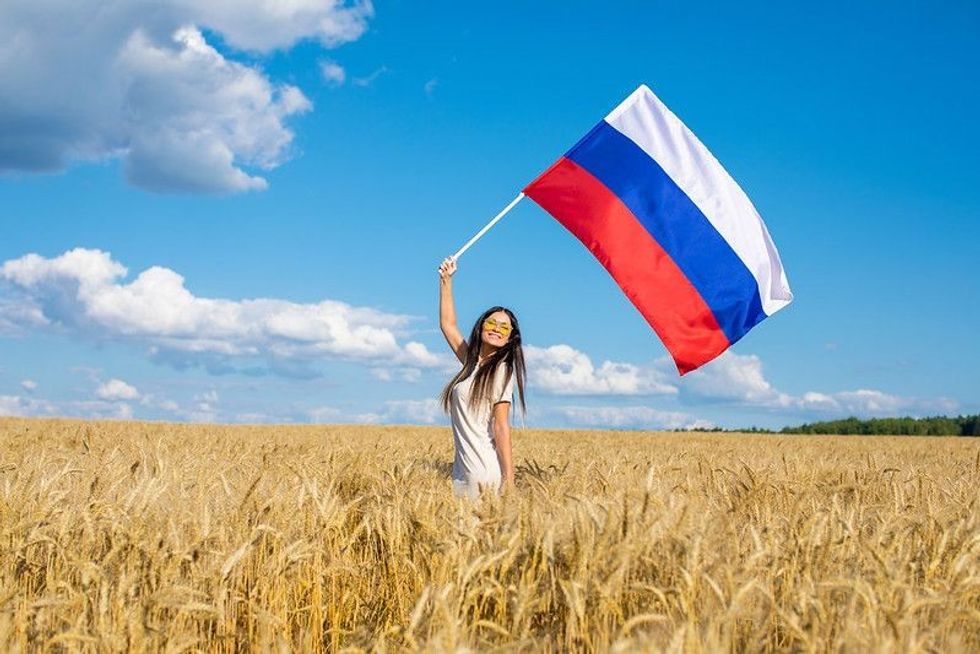 Young beautiful girl waving a Russian flag