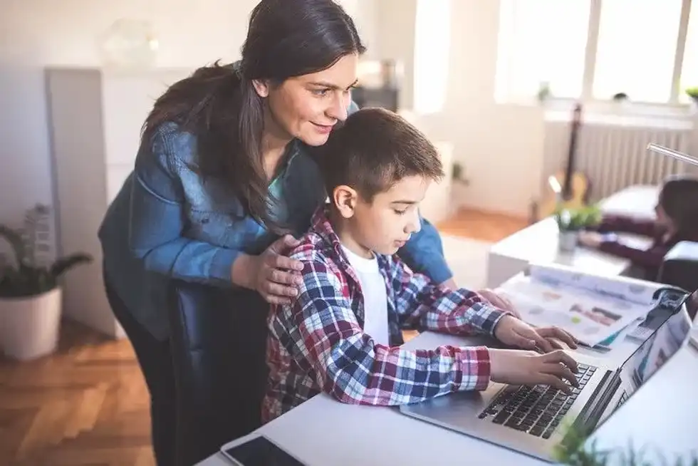 Young boy learning how to type.