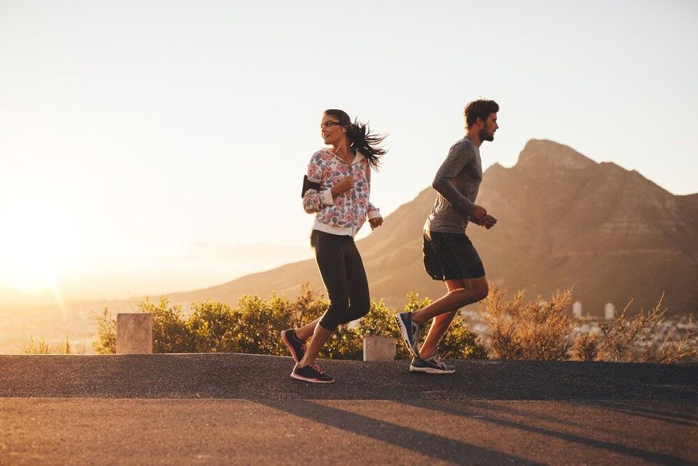 Young couple jogging early in morning, with woman looking back over her shoulder
