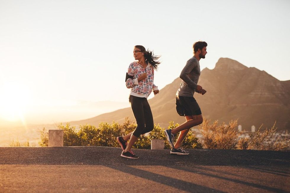 Young couple jogging early in morning, with woman looking back over her shoulder.
