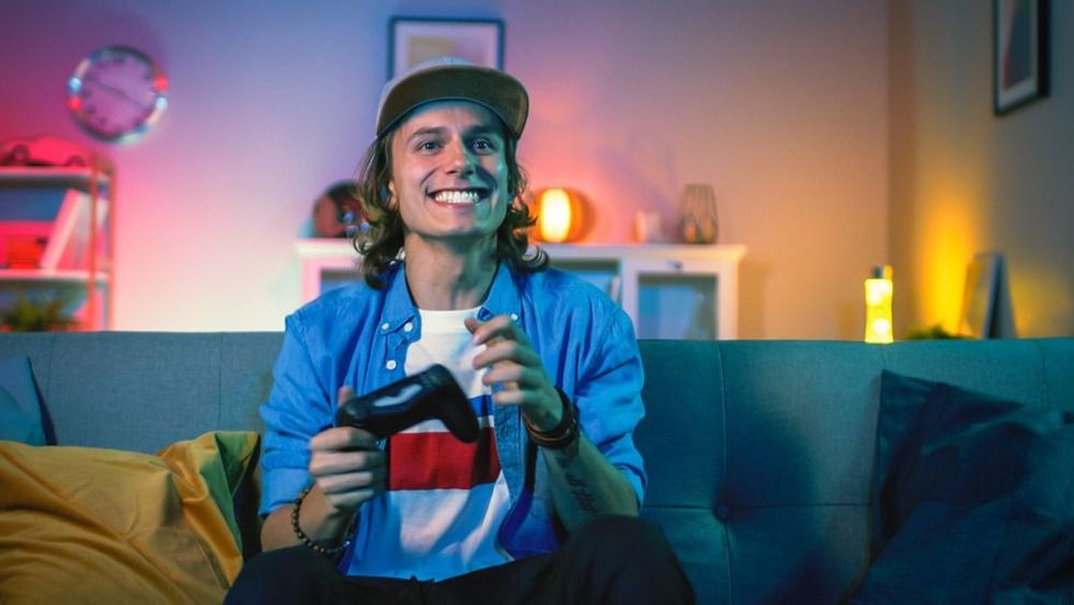 Young gamer playing video games and smiling