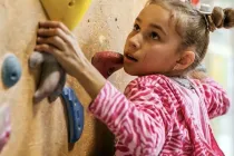 Young girl climbing the rock wall at Clip 'N Climb Tonbridge.