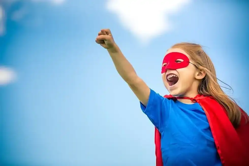 Young girl dressed up as a superhero.