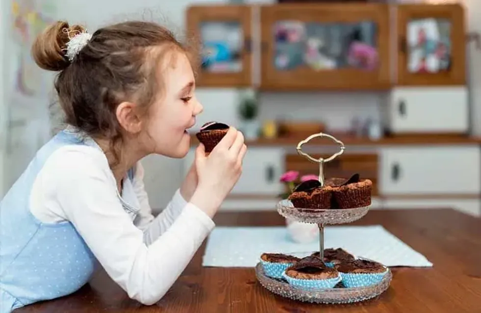 Young girl enjoying a homemade chocolate cupcake.