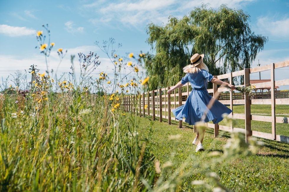 Young girl in straw hat with flowers