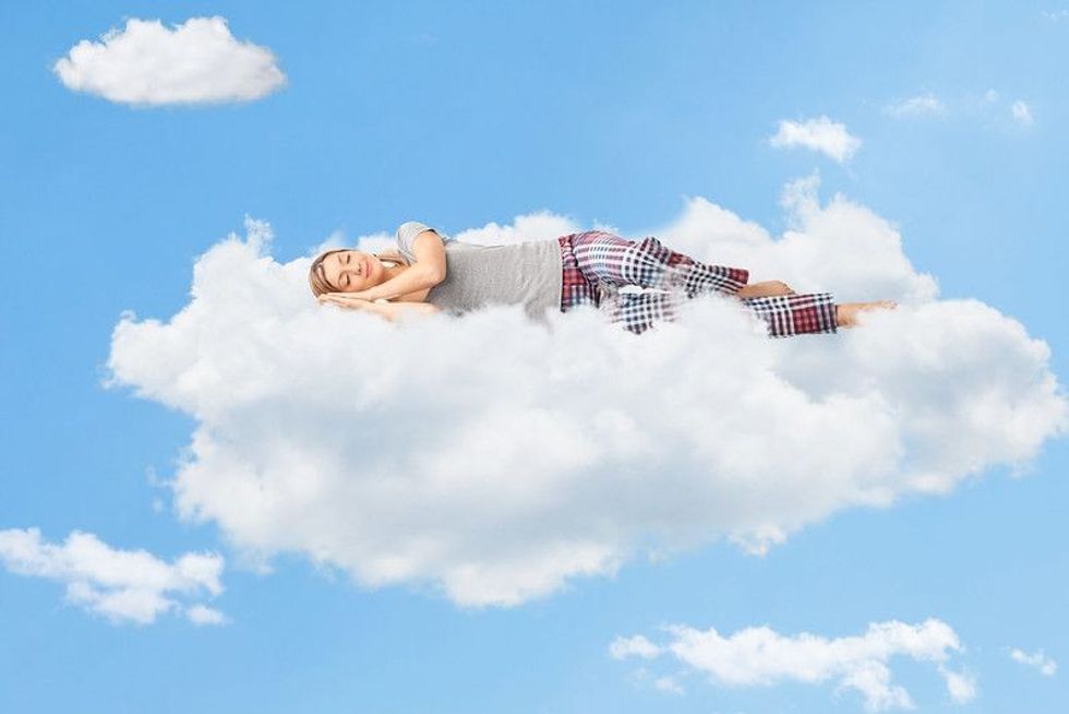 Young girl sleeping over clouds