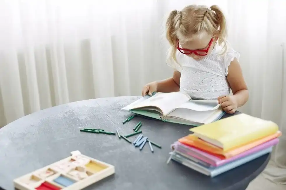 Young girl wearing red glasses, sat at the table learning the Viking timeline.