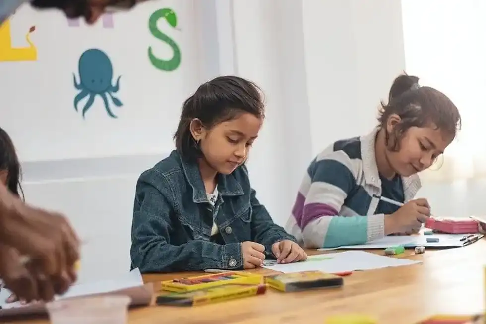 Young girls sat at the desk in the science classroom learning about the human life cycle.