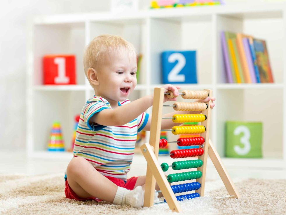 Young kid playing with abacus toy.