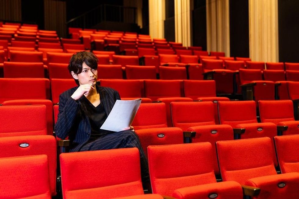 Young man sitting on theater seat